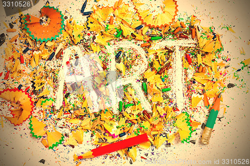 Image of art word on the background of colored pencil shavings