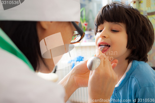 Image of doctor otolaryngologist looking boy throat