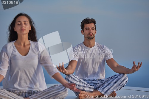 Image of young couple practicing yoga