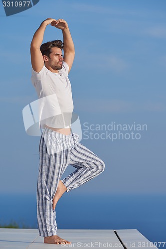 Image of young man practicing yoga