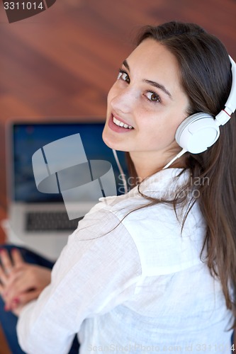 Image of relaxed young woman at home working on laptop computer