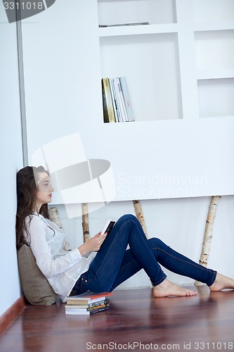 Image of relaxed young woman at home working on laptop computer
