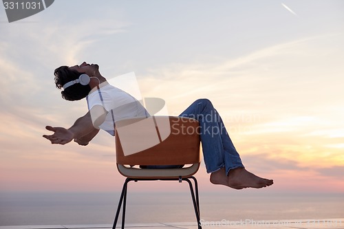 Image of relaxed young man at home on balcony