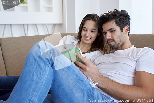 Image of couple at modern home using tablet computer