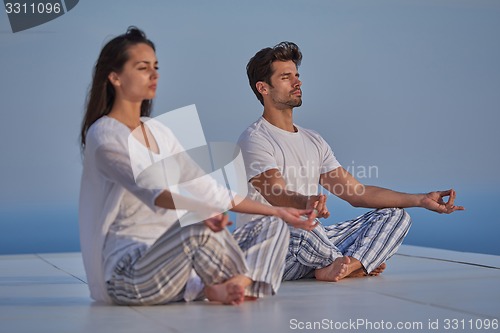 Image of young couple practicing yoga