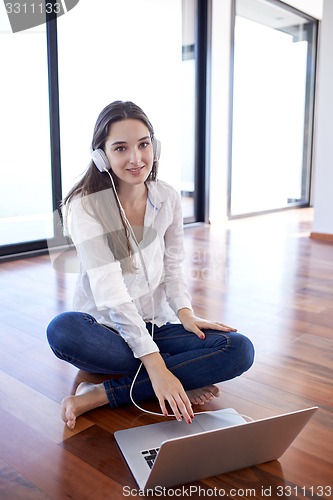 Image of relaxed young woman at home working on laptop computer