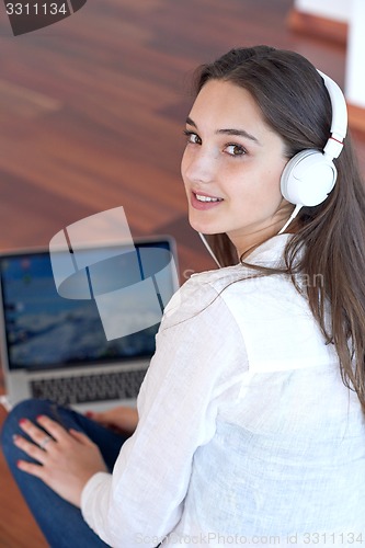 Image of relaxed young woman at home working on laptop computer