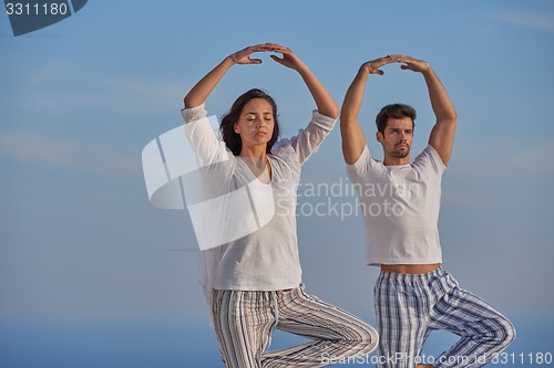 Image of young couple practicing yoga