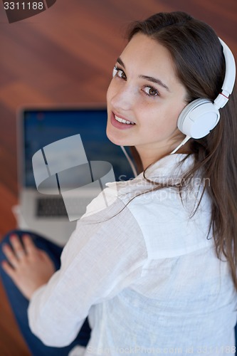 Image of relaxed young woman at home working on laptop computer