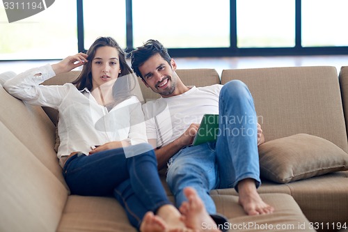 Image of couple at modern home using tablet computer