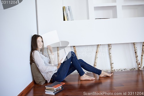 Image of relaxed young woman at home working on laptop computer