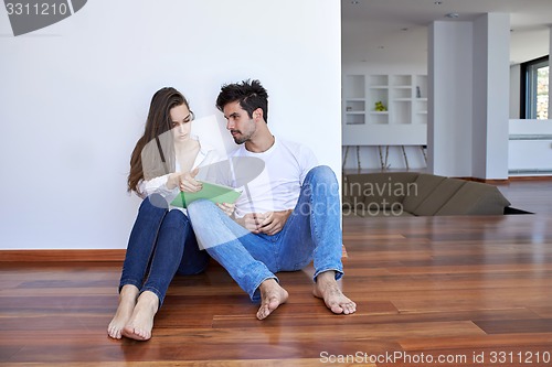 Image of couple at modern home using tablet computer