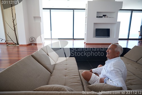 Image of Portrait of senior man relaxing in sofa