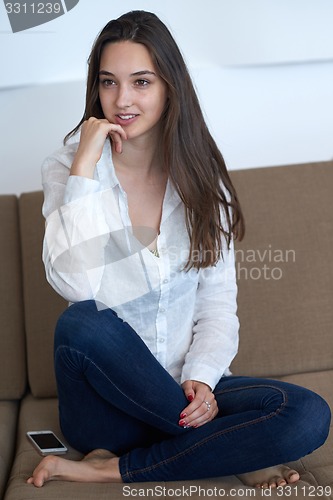 Image of relaxed young woman at home working on laptop computer