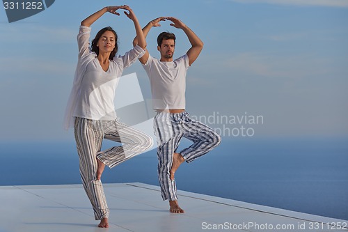 Image of young couple practicing yoga