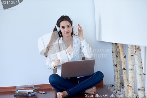Image of relaxed young woman at home working on laptop computer