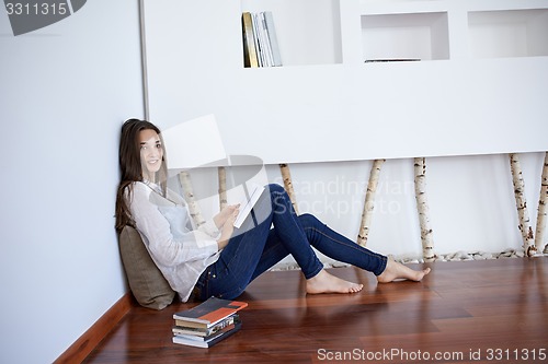 Image of relaxed young woman at home working on laptop computer