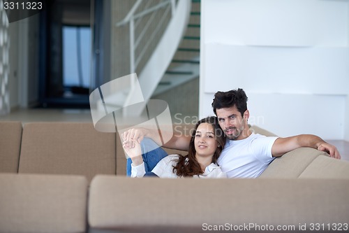 Image of relaxed young couple at home staircase