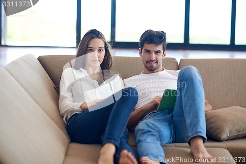 Image of couple at modern home using tablet computer