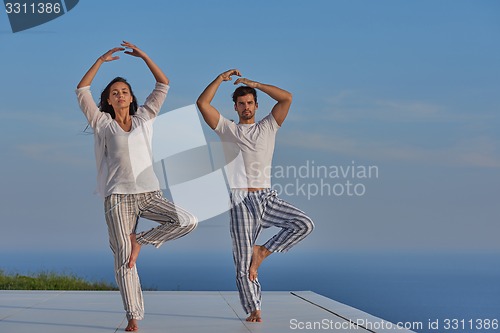 Image of young couple practicing yoga