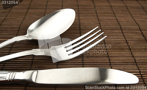 Image of Cutlery on a wooden background.