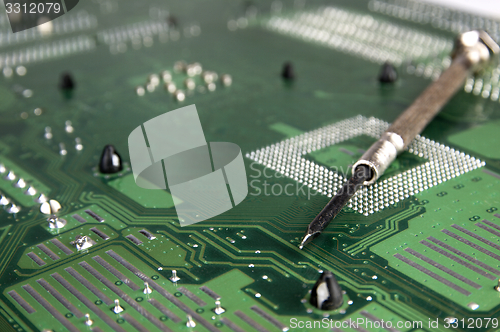 Image of Computer motherboard and Screwdriver.