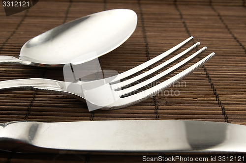 Image of Cutlery on a wooden background.