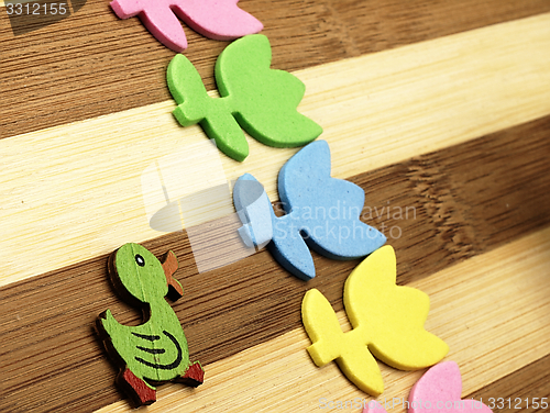 Image of Colorful cut tulips and duck on a chopping board.