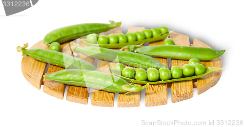 Image of Pods of peas on bamboo small board