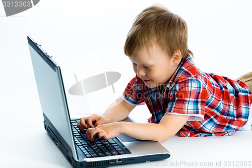 Image of boy lying on the floor with a laptop