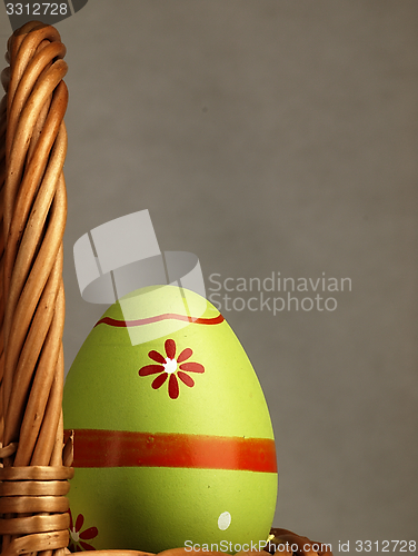 Image of Colorful Easter egg in the company of ordinary eggs.