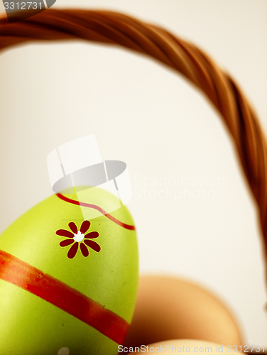 Image of Colorful Easter egg in the company of ordinary eggs.