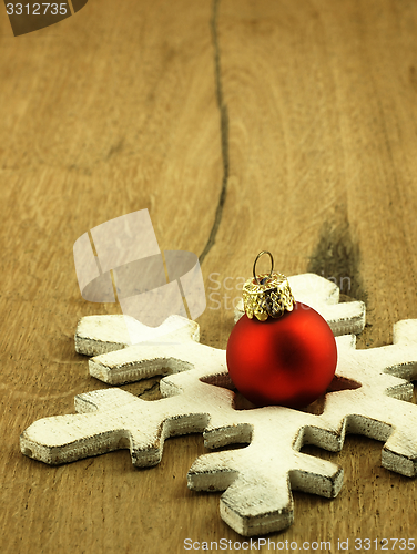 Image of Red Christmas bauble on a wooden oak background.