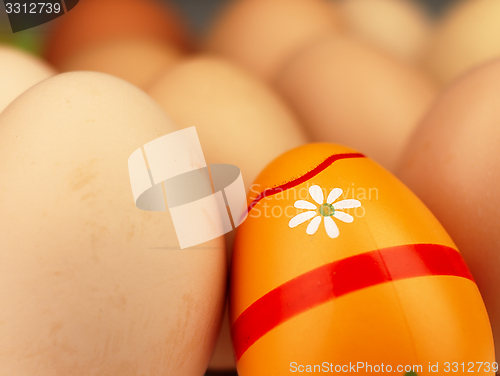 Image of Colorful Easter egg in the company of ordinary eggs.