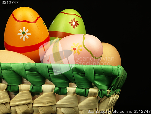 Image of Colorful Easter eggs in the company of ordinary eggs.