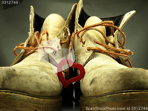 Image of Pair of heavy military boots and red heart.