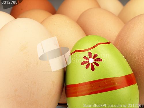 Image of Colorful Easter egg in the company of ordinary eggs.