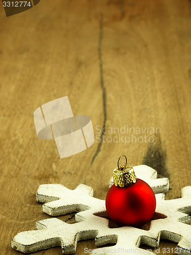 Image of Red Christmas bauble on a wooden oak background.