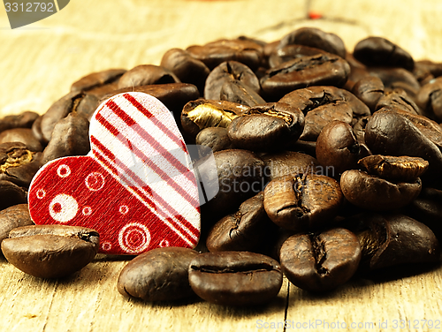Image of Heart and Coffee beans close-up on wooden, oak table.