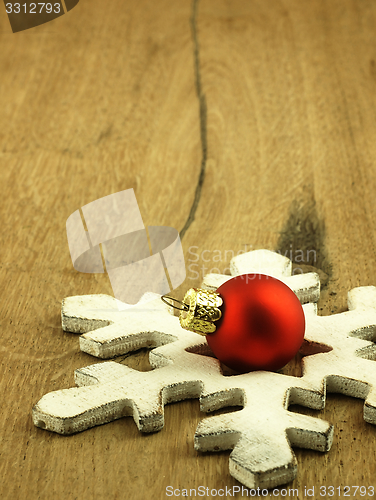 Image of Red Christmas bauble on a wooden oak background.
