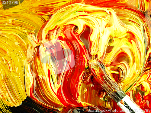 Image of Colored paint mixed on palette. Dirty brush in the foreground.