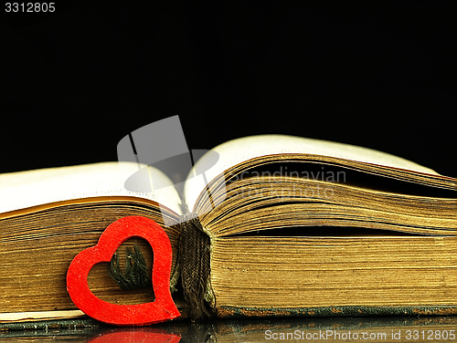 Image of Heart and old, open book with a damaged cover.