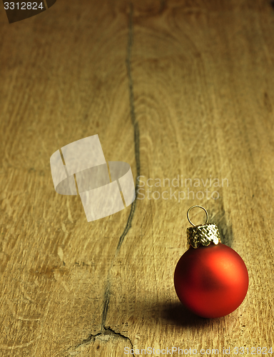 Image of Red Christmas bauble on a wooden oak background.