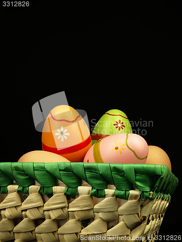 Image of Colorful Easter eggs in the company of ordinary eggs.