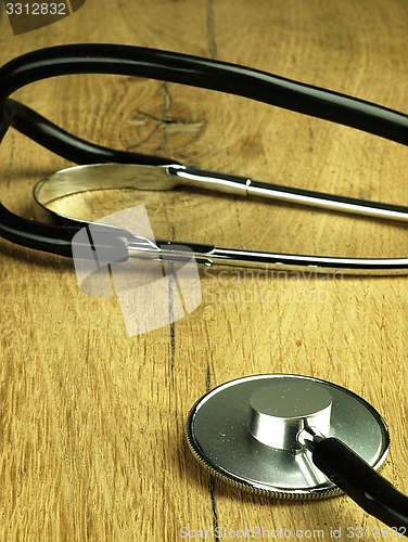 Image of Medical stethoscope on a wooden desk.