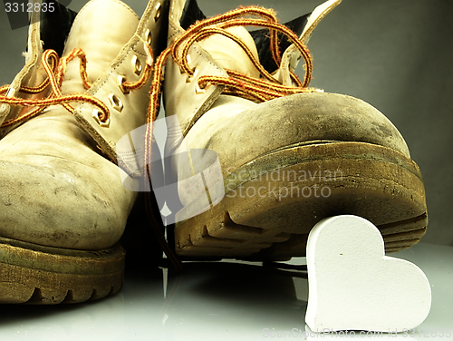 Image of Heavy military boots trampling heart.