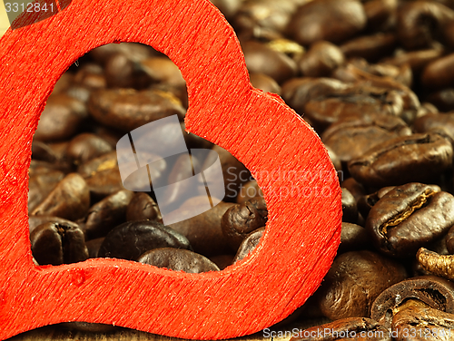 Image of Heart and Coffee beans close-up on wooden, oak table.