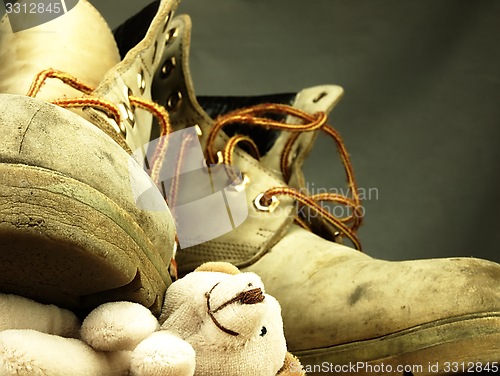 Image of Teddy bear crushed by a heavy, old military boot.