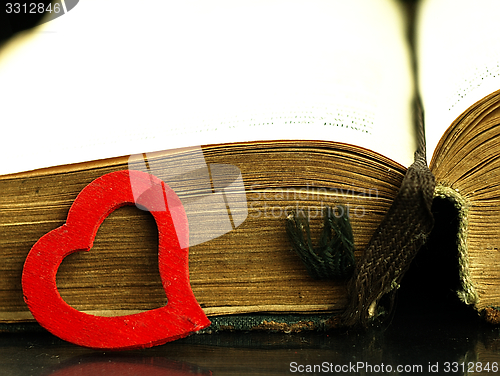 Image of Heart and old, open book with a damaged cover.