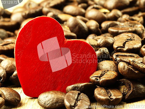Image of Heart and Coffee beans close-up on wooden, oak table.